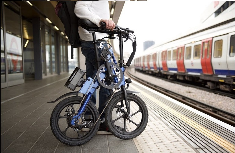 guy on a train station with fold away bike