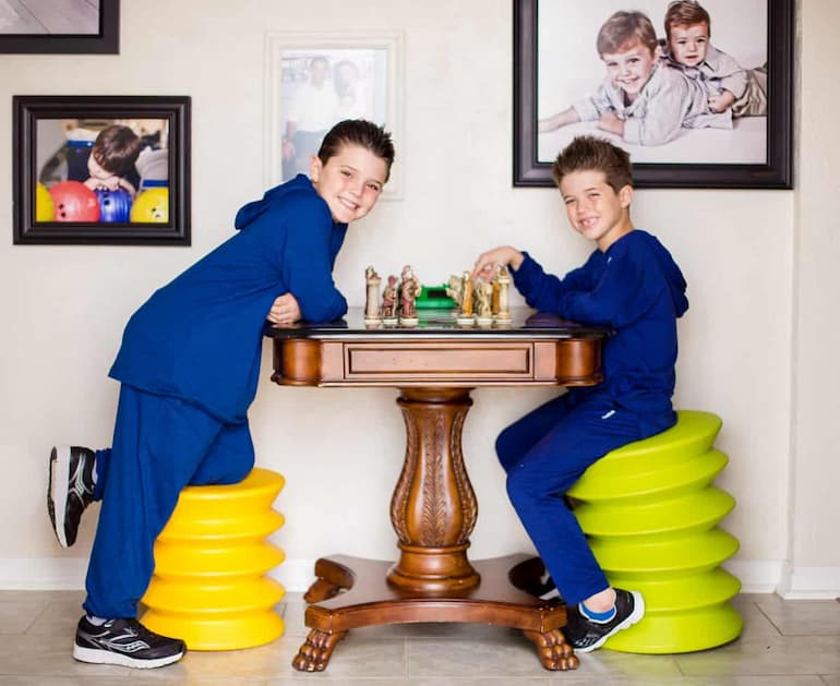 Two children sitting on wobble stools and playing