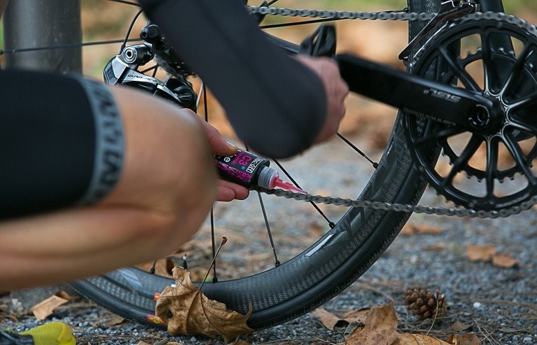 man cleaning bicycle drivetrain
