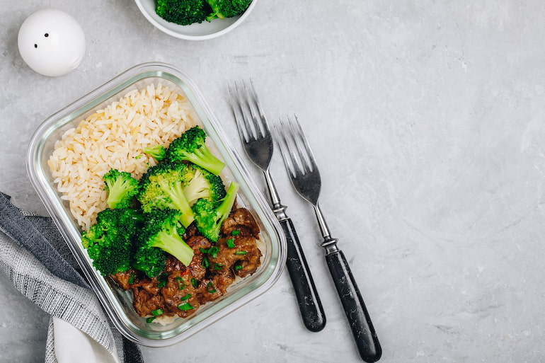 a high protein meal in a plastic container containing chicken, broccoli and rice