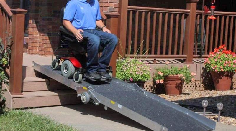 Man in wheelchair on ramp in front of a house