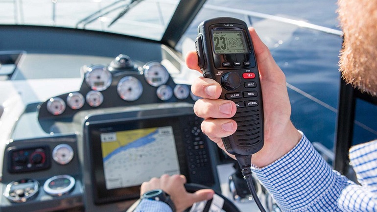 man speaking on VHF radios on a boat